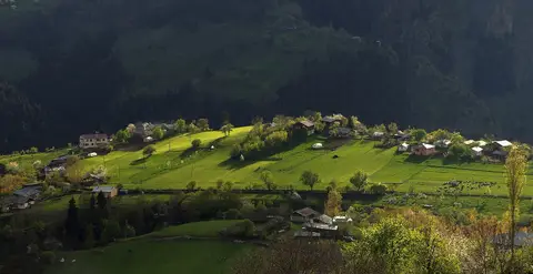 Artvin Şavşat'ta ormanlık yamaçlar arasında güneş alan çayırlar ve Yavuzköy evleri