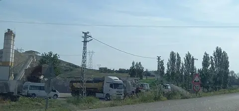 Çorum Bayat'taki Yeniköy'ün önünde yol kenarında park etmiş kamyonlar ve kavaklar