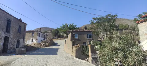 Gökçeada Dereköy'de taş evler arasından geçen parke taşlı köy yolu