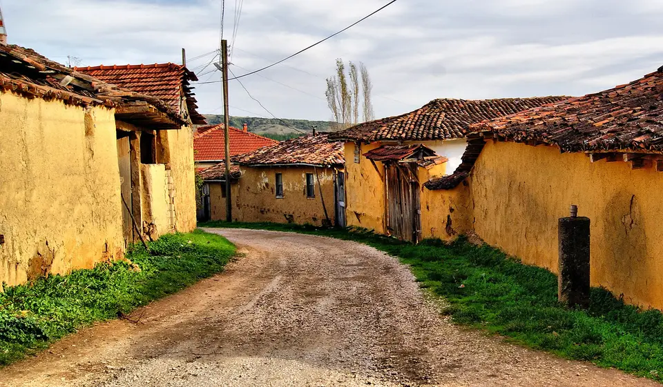 Yenişehir'e bağlı Kavaklı'da toprak yolun iki yanında sarı sıvalı, kiremit çatılı evler