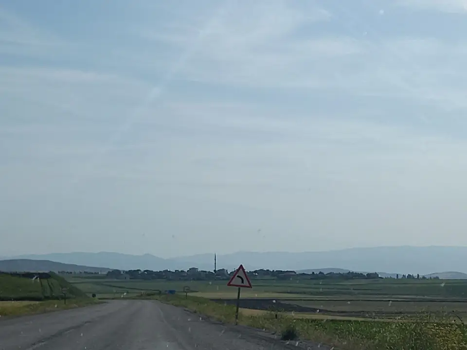 Bayat'a bağlı Emirhalil köyünün D180 karayolundan görünen ova ve yol kenarı levhası