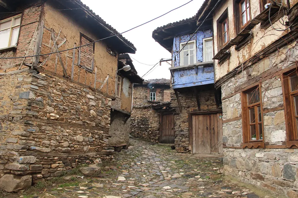 Cumalıkızık'ta taş zeminli dar sokağın iki yanında taş ve ahşaptan çıkmalı köy evleri