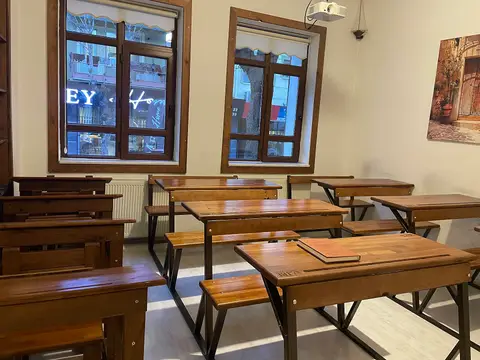 Eski tip ahşap okul sıralarının bulunduğu bir sınıf