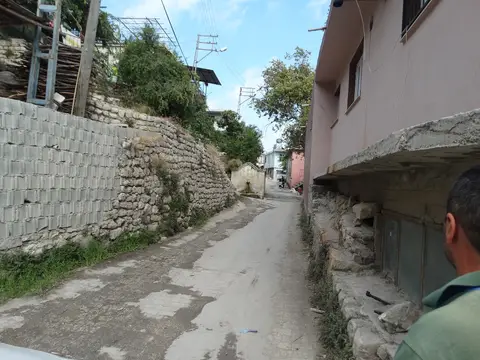Hıdırbey köyünde evlerin arasından geçen dar bir köy yolu