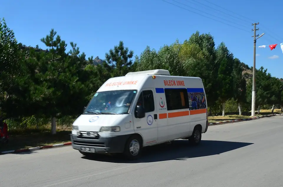 Ağaçlıklı bir yolda ilerleyen UMKE ambulansı