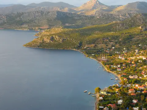 Marmaris Söğüt köyünün koya inen yamaçlardaki evleri ve arkadaki dağlar
