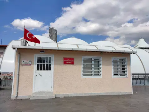 Çatısında Türk bayrağı dalgalanan, tek katlı ve pencereleri parmaklıklı Hasanpaşa muhtarlık binası