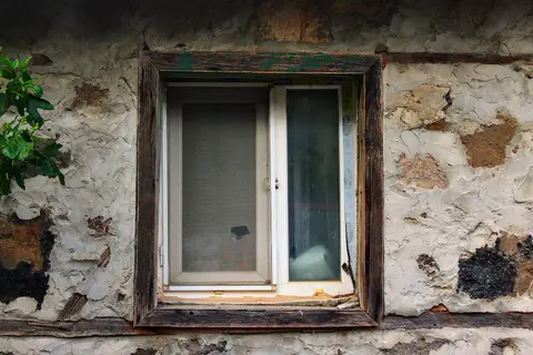 Sıvası dökülmüş taş duvarlı eski bir köy evinin ahşap çerçeveli penceresi